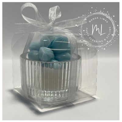 Vela decorativa azul em copo de vidro transparente com laço branco e embalagem de plástico