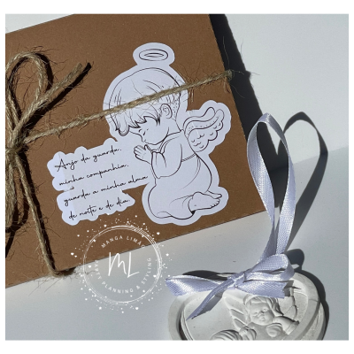 Cartão castanho com etiqueta de anjo desenhado e texto, pendente branco com relevo de anjo e fita.