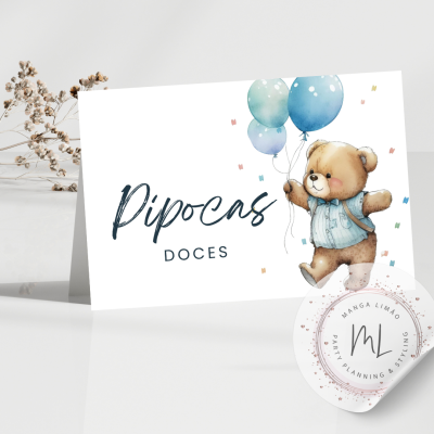 Cartão dobrado com texto 'Pipocas Doces' e desenho de urso com balões azuis