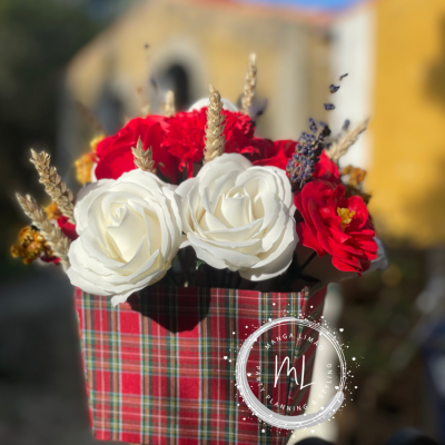 Arranjo de flores artificiais em vaso com padrão xadrez vermelho e verde