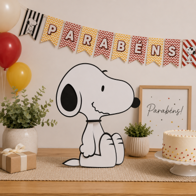 Decoração de festa com Snoopy, bolo, plantas, presente e bandeirola colorida com texto PARABÉNS