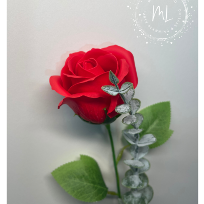 Rosa artificial vermelha com folhas verdes e raminho prateado