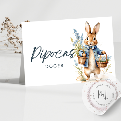 Cartão com coelho e texto Pipocas DOCES numa mesa branca com flores secas ao fundo.