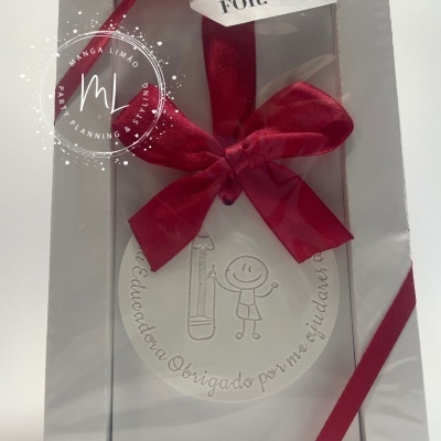 Ornamento branco redondo com texto e fita vermelha em caixa transparente