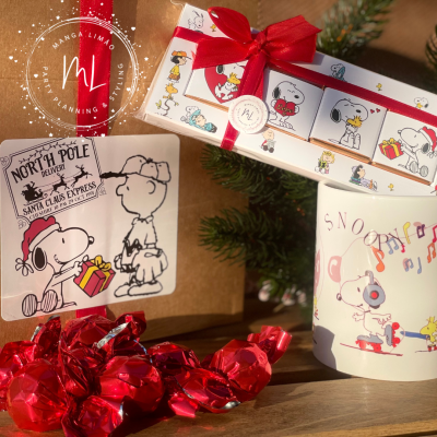 Produtos Snoopy natalícios com caixa de presente, caneca e papelaria em fundo de madeira e decoração natalícia