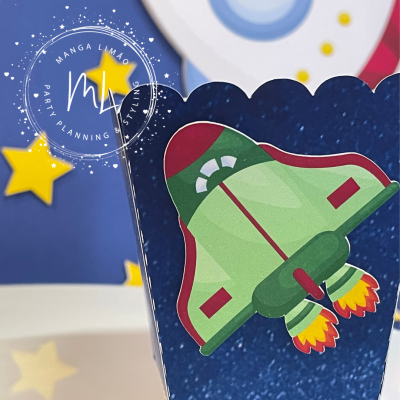 Embalagem azul escura com nave espacial verde e fundo com estrelas amarelas