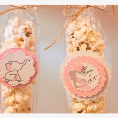 Embalagens transparentes com pipocas e etiquetas decorativas rosa e branco