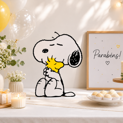 Decoração de festa com balões, flores, vela, escultura do Snoopy, bolo e quadro com texto Parabéns! em madeira.