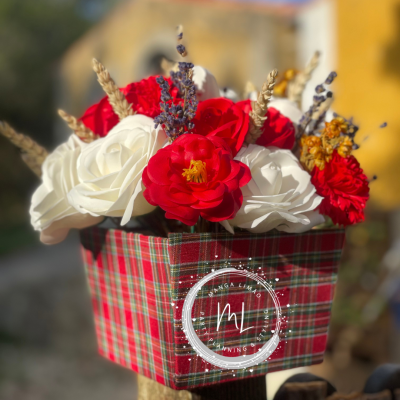 Arranjo floral em caixa xadrez com flores vermelhas, brancas e elementos secos