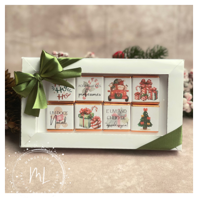 Caixa branca de chocolates com laço verde e embalagens natalícias