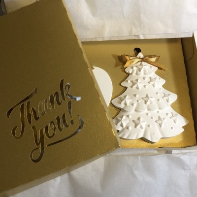 Decoração branca de árvore de Natal em caixa dourada com texto 