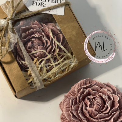 Caixa com flor decorativa cor-de-rosa em papel frisado e palha, amarrada com fita de cetim