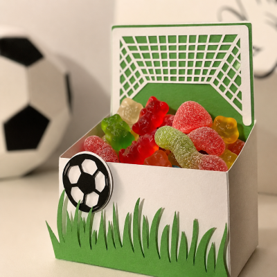 Embalagem de papel com gomas coloridas e decoração de futebol