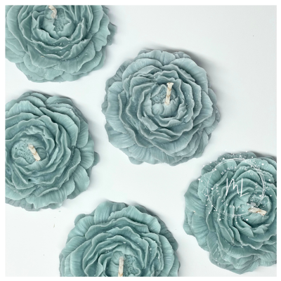 Velas em forma de flores azuis sobre superfície branca