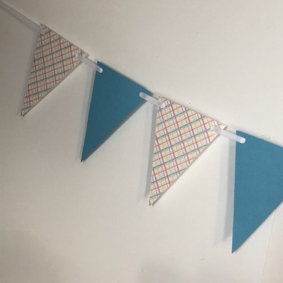 Bandeirolas triangulares em tecido xadrez e azul penduradas na parede