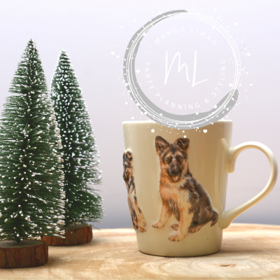 Caneca branca com desenhos de cães pastor alemão e duas árvores de Natal verdes com neve artificial