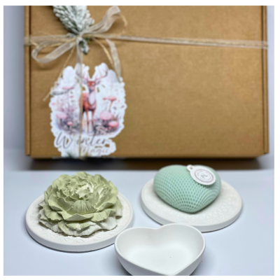 Caixa de presente com laço e etiqueta decorativa de veado, flores e coração decorativo sobre pratos e recipiente em formato de coração