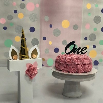 Bolo rosa decorado com topper One e número 1 decorativo com chifres de unicórnio