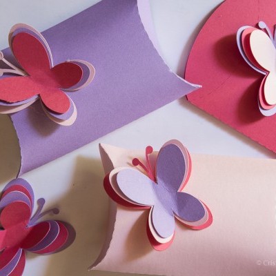 Caixas pequenas coloridas com borboletas de papel em camadas