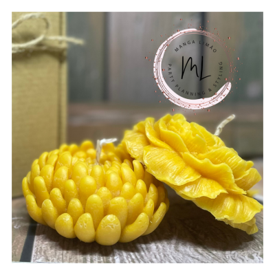 Dois objetos amarelos em forma de flores com textura detalhada sobre superfície de madeira ao lado de caixa de papel castanho