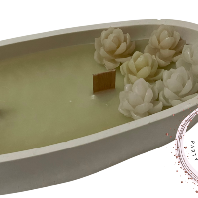 Vela branca oval com flores decorativas brancas e selo MANGA LIMÃO