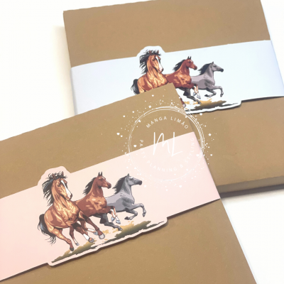 duas agendas com capas castanhas e faixas com ilustração de cavalos