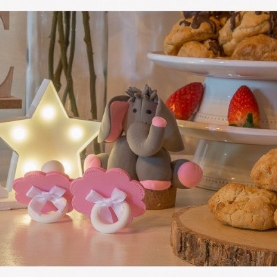 Chupetas decorativas rosa, elefante cinzento, bolos e luz em estrela