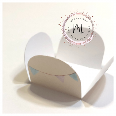 Caixa branca aberta com ilustração de bandeirolas coloridas