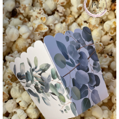 Caixa de pipocas decorada com folhas sobre pipocas