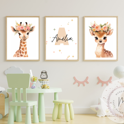 Três quadros infantis com girafa, nome Amélia e veado em molduras de madeira, acima de mesa e cadeiras verdes claras