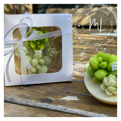 Arranjo de flores verdes e brancas em caixa branca com laço sobre mesa de madeira