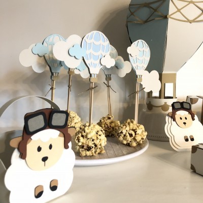 Doces decorativos em forma de ovelhas e balões de ar quente sobre prato branco