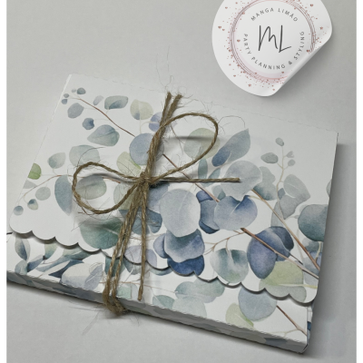 Cartão decorativo com padrão de folhas amarrado com cordão de ráfia e etiqueta redonda