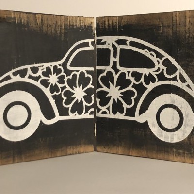 Desenho branco de carro clássico com flores em duas placas de madeira escuras