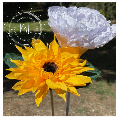 Flores artificiais amarelas e brancas detalhadas com folhas verdes ao ar livre