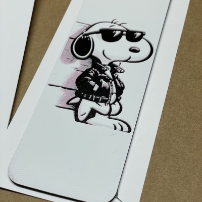 Marcador de livro branco com desenho do Snoopy em relevo