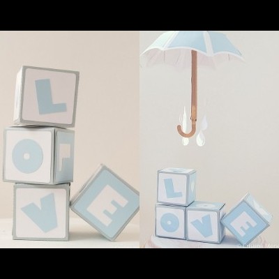 Cubos com letras formando LOVE, guarda-chuva branco suspenso e decoração azul clara