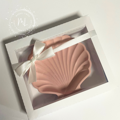 Prato decorativo rosa em forma de concha numa caixa branca com fita branca.