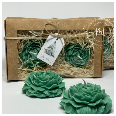 Velas verdes em forma de flor em caixa de papel kraft com etiqueta de Natal