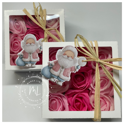 Caixas com rosas artificiais rosa e etiqueta de Pai Natal