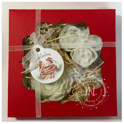 Caixa vermelha com flores brancas artificiais e etiqueta de Natal