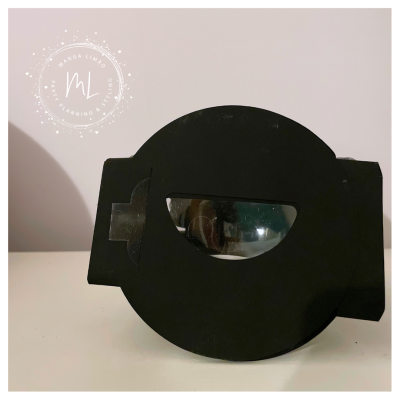 Suporte preto circular com janela semicircular transparente sobre superfície clara