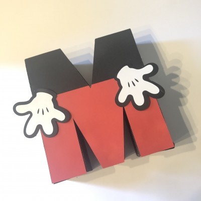 Caixa em forma de letra M com mãos brancas