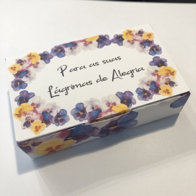 Caixa decorativa branca com flores roxas e amarelas e texto em português.