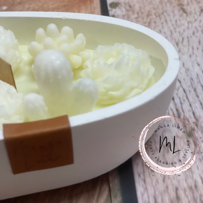 Conjunto de velas em forma de plantas suculentas brancas dentro de recipiente oval branco