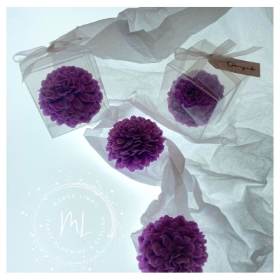 Flores artificiais roxas em embalagens transparentes sobre tecido branco translúcido