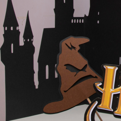 Chapéu Seletor com castelo ao fundo e letras HARRY amarelas