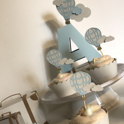 Cupcakes decorados com balões de ar quente azuis e nuvens em base branca
