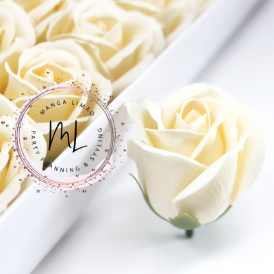 Rosas artificiais creme com folhas verdes organizadas em caixa branca com logótipo