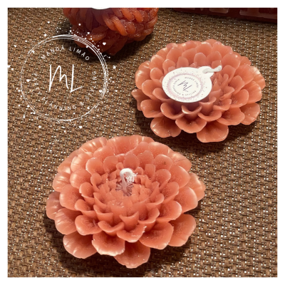 Velas florais cor-de-rosa com etiqueta ML numa superfície castanha texturizada